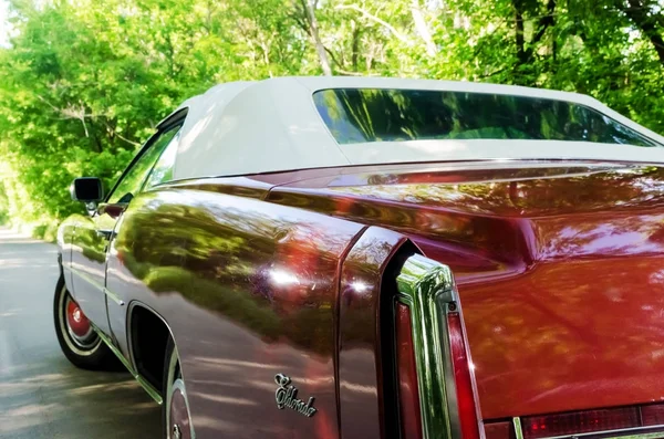 Nevinomyssc, russland - 13. Mai 2016: automobile. Offsite-Fotografien alter amerikanischer Autos. Cadillac Eldorado Cabriolet 1976s. Rückansicht einer Maschine auf einer Landstraße im Wald — Stockfoto