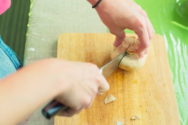 Büyük ahşap mantarları bir kesme tahtası üzerinde sote eller.