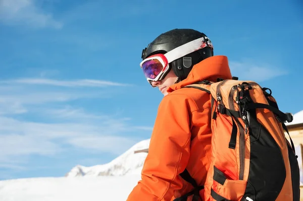 Portrét lyžař v pomeranč celkově s batohem na zádech v přilbě stojí na pozadí krásné horské krajiny Kavkazský — Stock fotografie