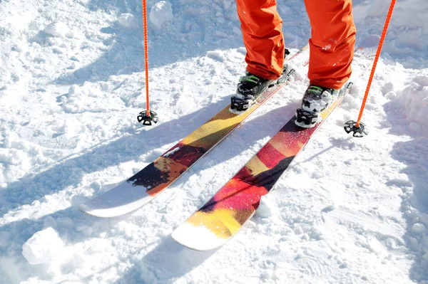 Esquiador de atleta de pernas em um geral cor-de-laranja em um esporte esquiando na neve em um dia ensolarado. O conceito de esportes de inverno — Fotografia de Stock