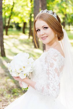 Beyaz elbise ve bir buket çiçek elleri içinde güzel bir gelin portresi