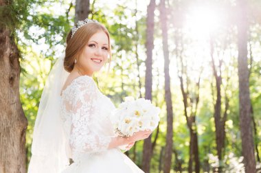 Beyaz elbise ve bir buket çiçek elleri içinde güzel bir gelin portresi