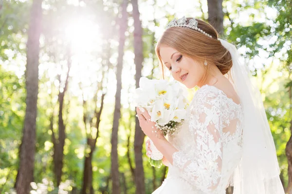 Портрет красивої нареченої в білій сукні і букет квітів в руках — стокове фото