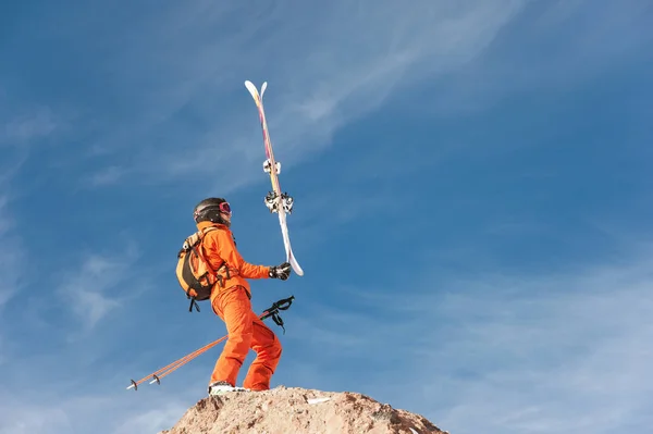 스키 선수는 높은 바위의 가장자리에 서 있는 균형 푸른 하늘과 촉 모 구름에 대 한 그의 손에 그의 스키 — 스톡 사진