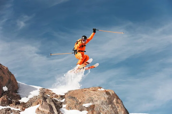 Un esquiador atleta está saltando desde lo alto de la roca en las montañas . — Foto de Stock