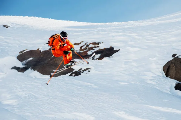 An athlete skier is jumping from high rock high in the mountains. — Stock Photo, Image