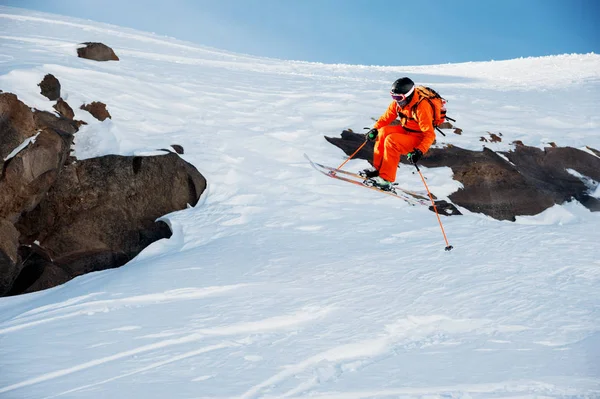 En idrottsman skidåkare är att hoppa från höga klippa högt i bergen. — Stockfoto