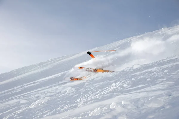 Лыжный спортсмен в свежем снежном порошке мчится по снежному склону — стоковое фото