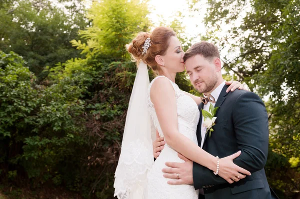Nahaufnahme Porträt eines liebenden Paares, das sich vor sommerlichem Grün küsst — Stockfoto