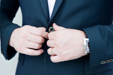 Ceketinin düğmesini sakalı ile bir takım elbise ile kuvvetli bir yeni evli takılır. Süper yakın çekim.