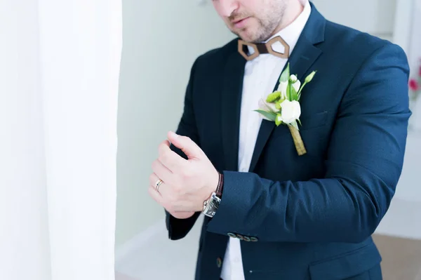 Tęgi Oblubieńca z brodą w garniturze dostosowuje rękaw jego kurtki. Super makro. — Zdjęcie stockowe