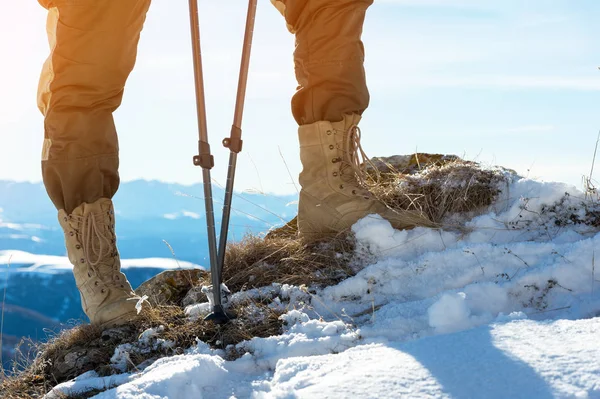 Detail nohy turisty v turistických botách s holemi pro Nordic walking stojící na kameni kámen v horách — Stock fotografie