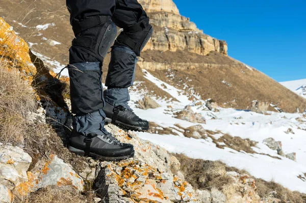 Detail nohy turisty v turistických botách s holemi pro Nordic walking stojící na kameni kámen v horách — Stock fotografie