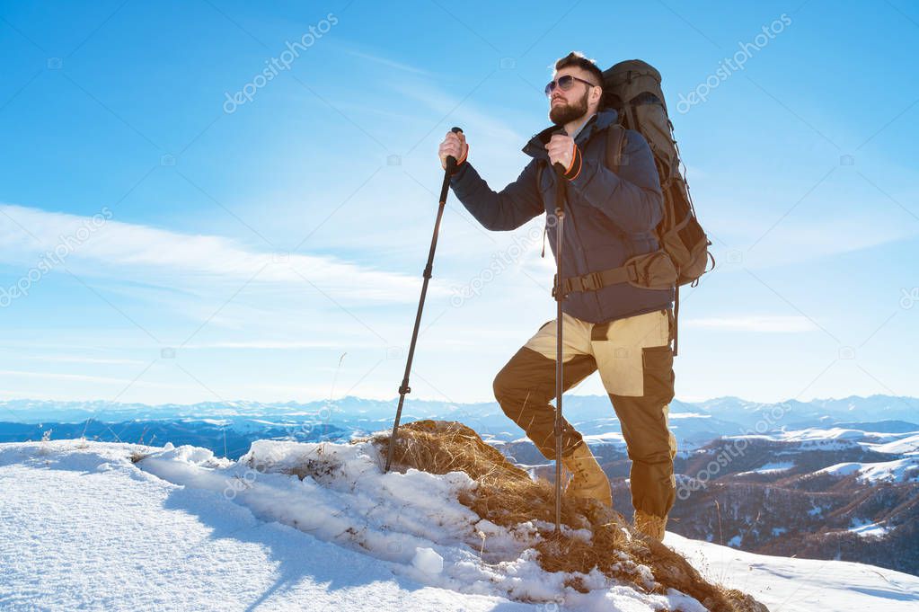 A hipster traveler with a beard wearing sunglasses in nature.