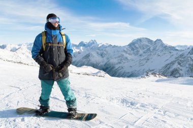 Profesyonel bir snowboard onun snowboard ile duruyor. Yakın çekim. Bir freerider portresi