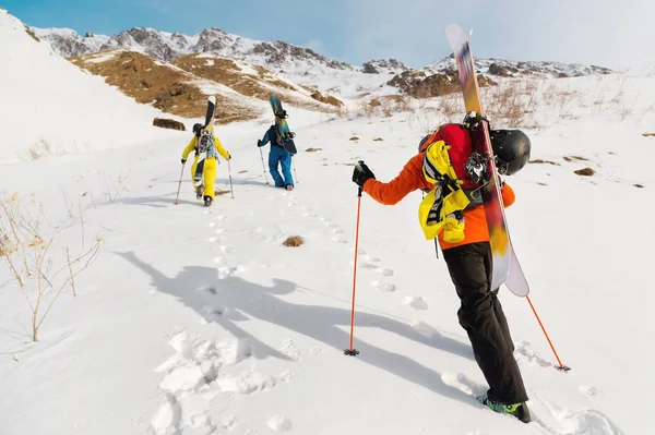 Un groupe de trois freeriders escalade la montagne pour le ski de fond le long des pistes sauvages de la — Photo