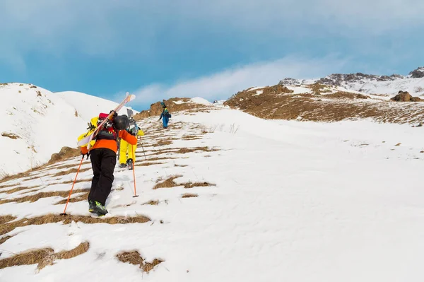 Un grup de trei freeriders urca pe munte pentru schi backcountry de-a lungul pârtiilor sălbatice ale — Fotografie, imagine de stoc