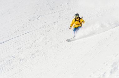 Bir adam bir snowboard freerider backcountry yüksek hızda bir yamaç iner.