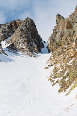 Yakın çekim. Keskin kayalara arasında karlı bir verdi görünümünü.