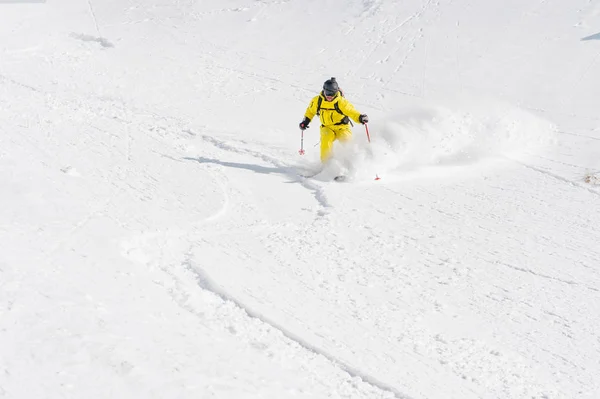 Een mannelijke skiër freerider met een baard afstamt van het binnenland op hoge snelheid van de helling — Stockfoto