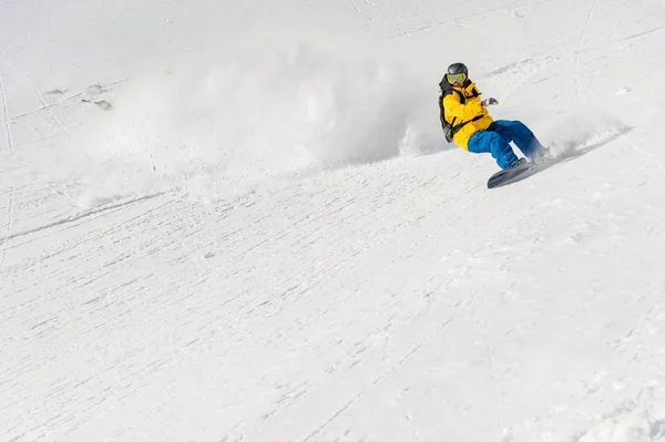 Um homem um freerider snowboarder desce um sertão em alta velocidade de uma inclinação — Fotografia de Stock