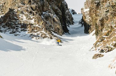 Bir adam bir snowboard freerider backcountry yüksek hızda bir yamaç iner.