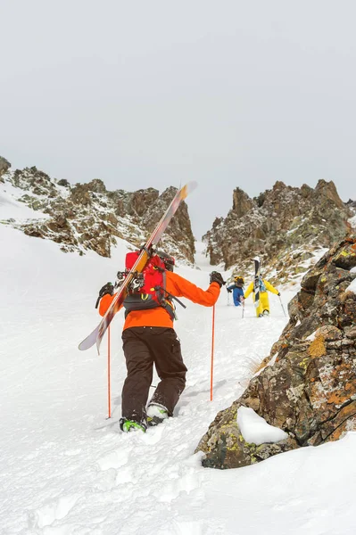 Schiorii extremi urcă în vârf de-a lungul couloir-ului dintre stânci înainte de coborârea freeride backcountry — Fotografie, imagine de stoc