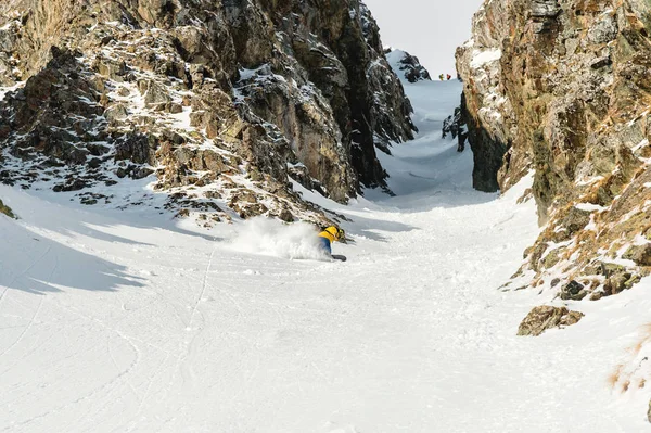 Ένας άνθρωπος ένα ελεύθερο snowboarder κατεβαίνει ένα backcountry σε υψηλή ταχύτητα από μια πλαγιά — Φωτογραφία Αρχείου