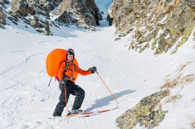 Bir sırt çantası içinde bir açılan çığ dübel abs ile gülümseyen mutlu freeride backcountry kayakçı portresi.