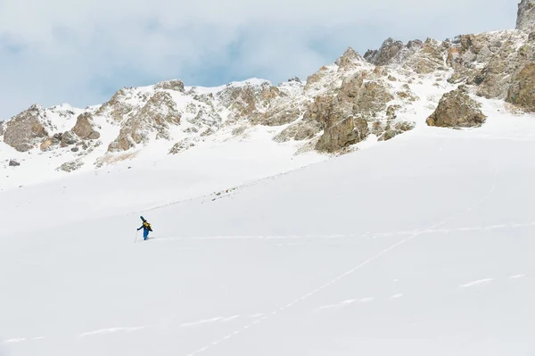 De freerider snowboard klimt de helling tot diepe sneeuw poeder met de apparatuur op de achterkant gefixeerd op de rugzak. — Stockfoto