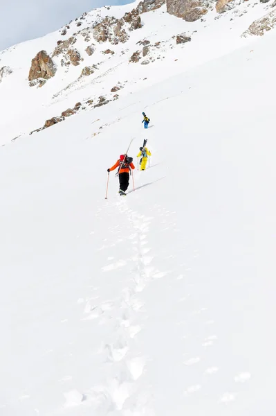 Δύο σκι freerider ανεβαίνει την πλαγιά σε βαθύ χιόνι με τον εξοπλισμό στο πίσω μέρος καθορίζεται με το σακίδιο. — Φωτογραφία Αρχείου