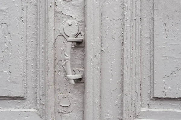Close-up fechaduras com cortinas e uma alça no cinza muitas vezes pintado rachado porta vintage de madeira de cano duplo do século passado com uma fenda de post . — Fotografia de Stock