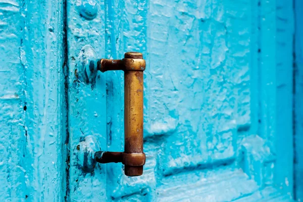 Szczegół otwory z zasłony i uchwyt na niebiesko, wiele razy malowane pęknięty lufami drewniane drzwi rocznika ubiegłego wieku z rozcięciem post. — Zdjęcie stockowe