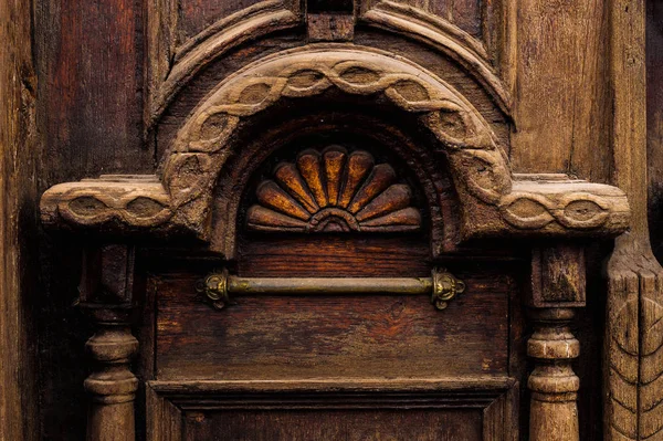 Вінтажний фон. Елементи старих різьблених дерев'яних дверей, прикрашені об'ємними різьбленими дерев'яними елементами, що імітують плетіння. Вінтажне поняття старих антикваріатів. Пофарбовані старі махагони — стокове фото