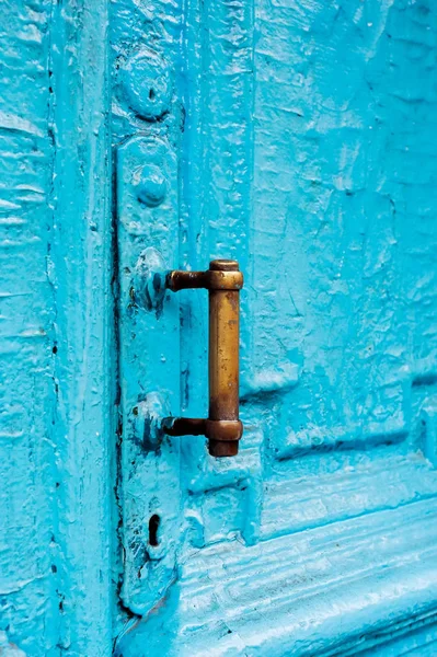 Close-up fechaduras com cortinas e uma alça no azul muitas vezes pintado rachado porta vintage de madeira de cano duplo do século passado com uma fenda de post . — Fotografia de Stock