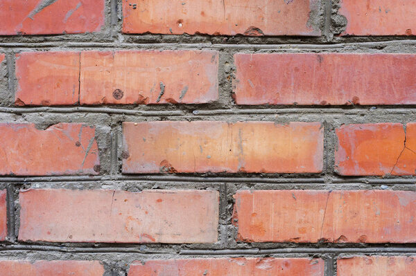 Textured background red brick wall with traces of old age and with different shades of bricks. Brick manual curve masonry and different color