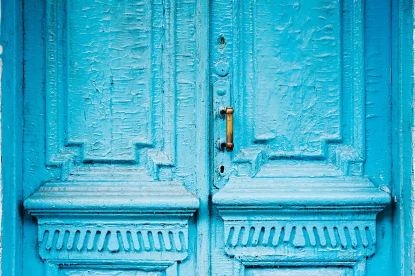 Buchi serratura close-up con tende e una maniglia sul blu molte volte dipinta incrinato porta d'epoca in legno a doppia canna del secolo scorso con una fessura post . — Foto Stock