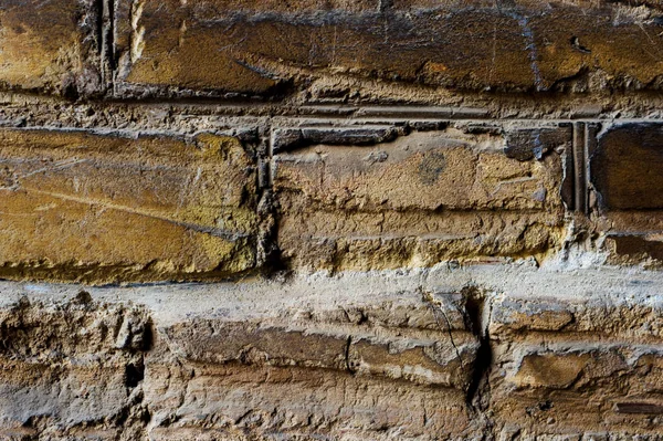 Close-up Fundo texturizado de alvenaria de tijolo velho amarelo pálido com arranhões horizontais profundos. Textura grunge do revestimento de tijolo velho deformado por impacto horizontal — Fotografia de Stock