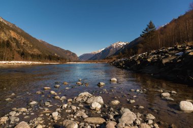 Gün ortasında sonbahar manzara sakin nehirde Kafkas Dağları yakın dönem taşlarla
