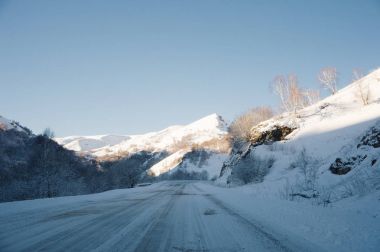 Kar parça Kuzey Kafkasya de kışın yol yol ve araba. Karla kaplı ağaçlar ve dağlar. Kış seyahat arabayla kavramı