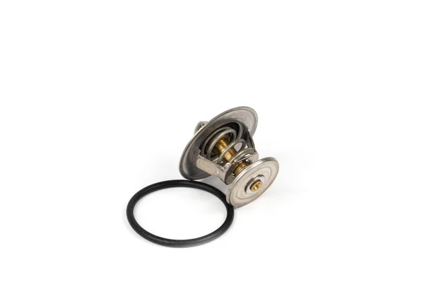 New car thermostat on a white isolated background next to a rubber gasket. Repair kit of spare parts for the replacement of the thermostat in the engine cooling system — Stock Photo, Image