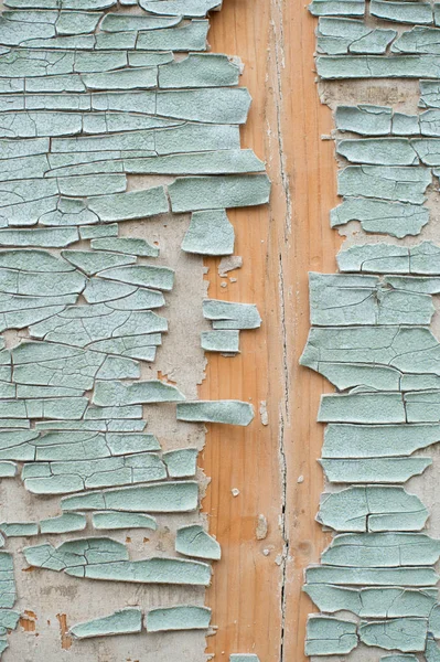 Un gran fondo texturizado la vieja tabla amarilla está cubierta con pintura verde. Exfoliante pintura verde en piezas grandes que faltan en el revestimiento de madera. El concepto de ruina y antigüedad vintage — Foto de Stock