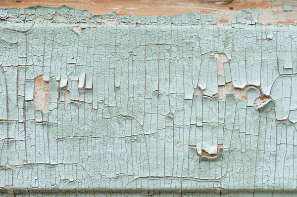 Un gran fondo texturizado la vieja tabla amarilla está cubierta con pintura verde. Exfoliante pintura verde en piezas grandes que faltan en el revestimiento de madera. El concepto de ruina y antigüedad vintage — Foto de Stock