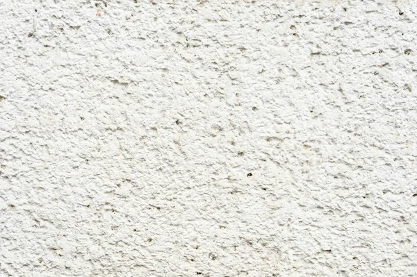 Textura profunda de piedra porosa pintada de blanco en la fachada del edificio. Textura de fondo de pared apedreada — Foto de Stock