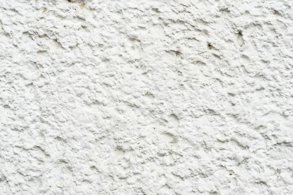 Primer plano Textura profunda de piedra porosa pintada de blanco en la fachada del edificio. Textura de fondo de pared apedreada — Foto de Stock