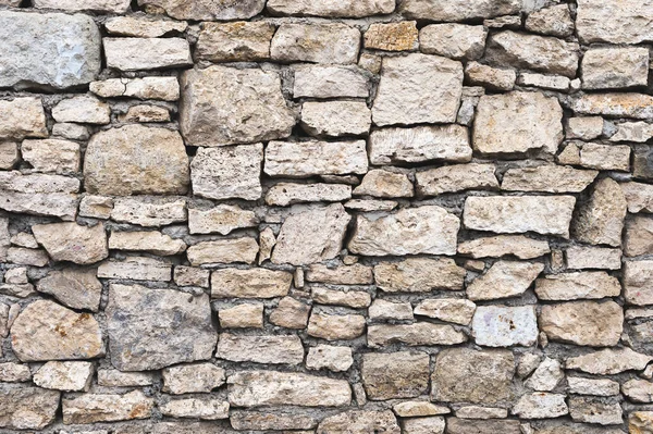 Close-up fundo texturizado é uma parede de pedra natural irregular feita de diferentes pedras sem uma mistura de ligação do tipo cimento. Fundo medieval — Fotografia de Stock