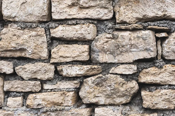 Close-up fundo texturizado é uma parede de pedra natural irregular feita de diferentes pedras sem uma mistura de ligação do tipo cimento. Fundo medieval — Fotografia de Stock