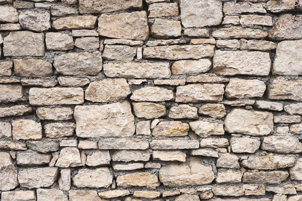 Close-up fundo texturizado é uma parede de pedra natural irregular feita de diferentes pedras sem uma mistura de ligação do tipo cimento. Fundo medieval — Fotografia de Stock