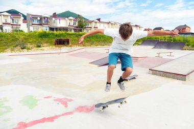 Bir çocuk bir kaykay üzerinde bir hile yaparak bir skate Park