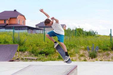 Bir çocuk bir kaykay üzerinde bir hile yaparak bir skate Park